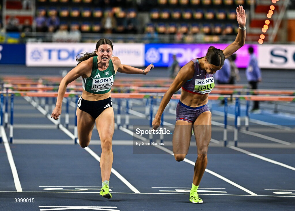 22 March 2026; Kate O'Connor of Ireland, left, and Anna Hall of United States dip for the line in the Women's 60m hurdles event in the Women's Pentathlon during day three of the World Athletics Indoor Championships at Kujawsko-Pomorska Arena in Torun, Poland. Photo by Sam Barnes/Sportsfile