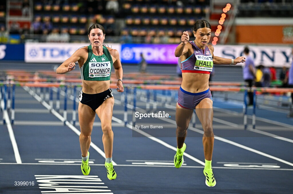 22 March 2026; Kate O'Connor of Ireland, left, and Anna Hall of United States cross the line in the Women's 60m hurdles event in the Women's Pentathlon during day three of the World Athletics Indoor Championships at Kujawsko-Pomorska Arena in Torun, Poland. Photo by Sam Barnes/Sportsfile
