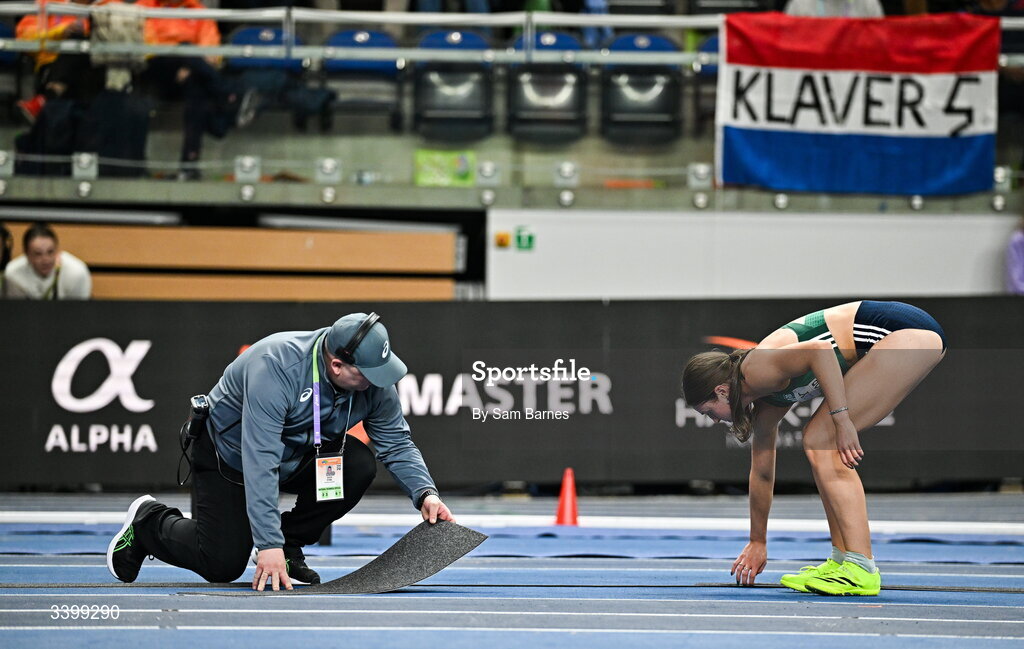 22 March 2026; Kate O'Connor of Ireland assists officials to repair the track before competing in the Women's high jump event in the Women's Pentathlon during day three of the World Athletics Indoor Championships at Kujawsko-Pomorska Arena in Torun, Poland. Photo by Sam Barnes/Sportsfile