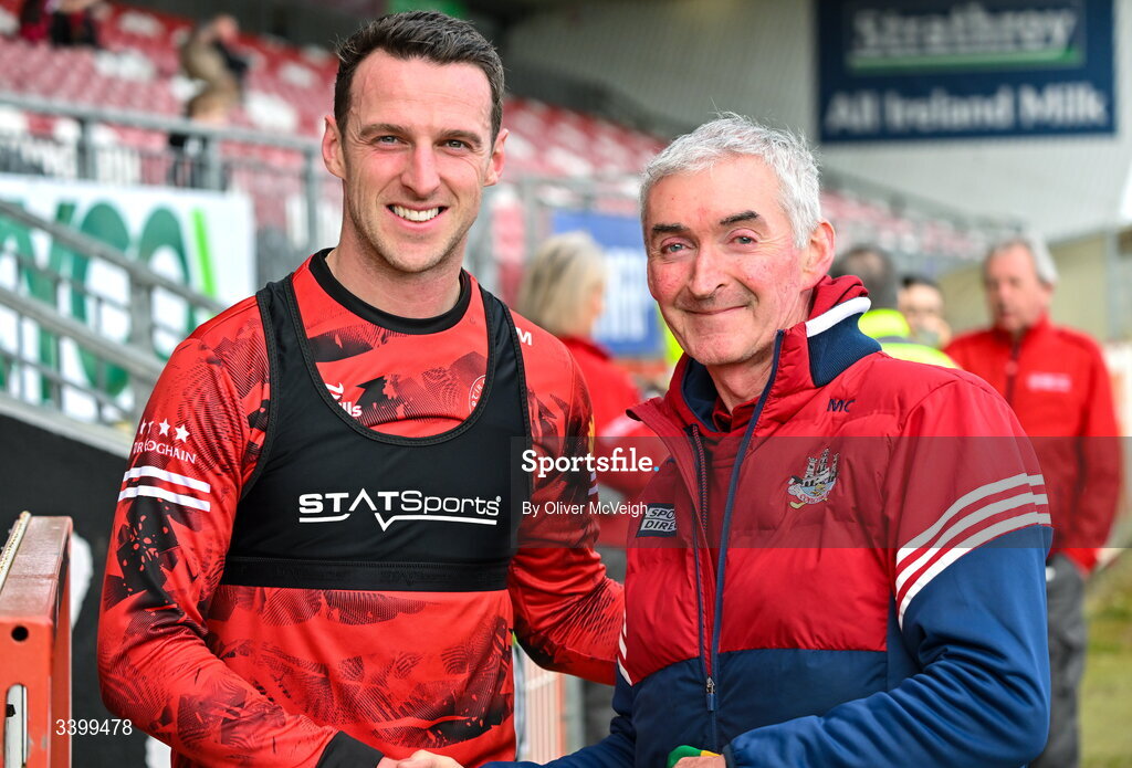 22 March 2026; Niall Morgan of Tyrone, left, pictured alongside Mick Curtin, who served as a Cork team assistant for 35 years, before the Allianz Football League Division 2 match between Tyrone and Cork at O'Neills Healy Park in Omagh, Tyrone. Photo by Oliver McVeigh/Sportsfile