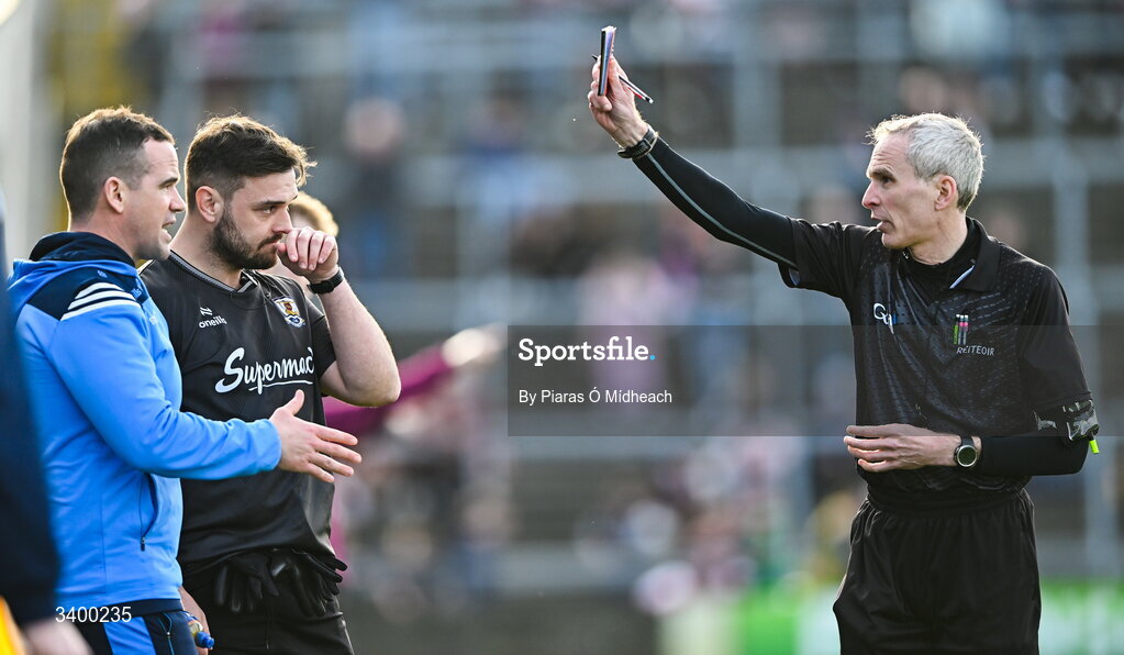 22 March 2026; Referee Fergal Kelly shows the red card to Dublin manager Ger Brennan and to Galway strength and conditioning coach Cian Breathnach McGinn before the start of the second half, during the Allianz Football League Division 1 match between Galway and Dublin at Pearse Stadium in Galway. Photo by Piaras Ó Mídheach/Sportsfile