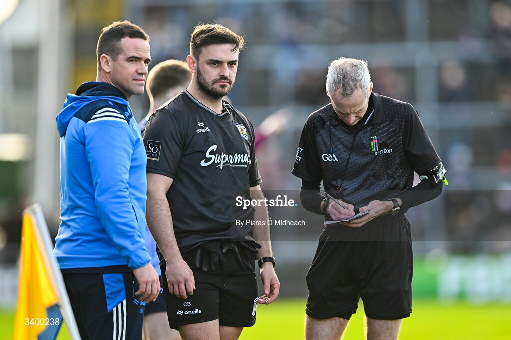 22 March 2026; Referee Fergal Kelly takes the names of Dublin manager Ger Brennan and to Galway strength and conditioning coach Cian Breathnach McGinn before sending them both off before the start of the second half during the Allianz Football League Division 1 match between Galway and Dublin at Pearse Stadium in Galway. Photo by Piaras Ó Mídheach/Sportsfile