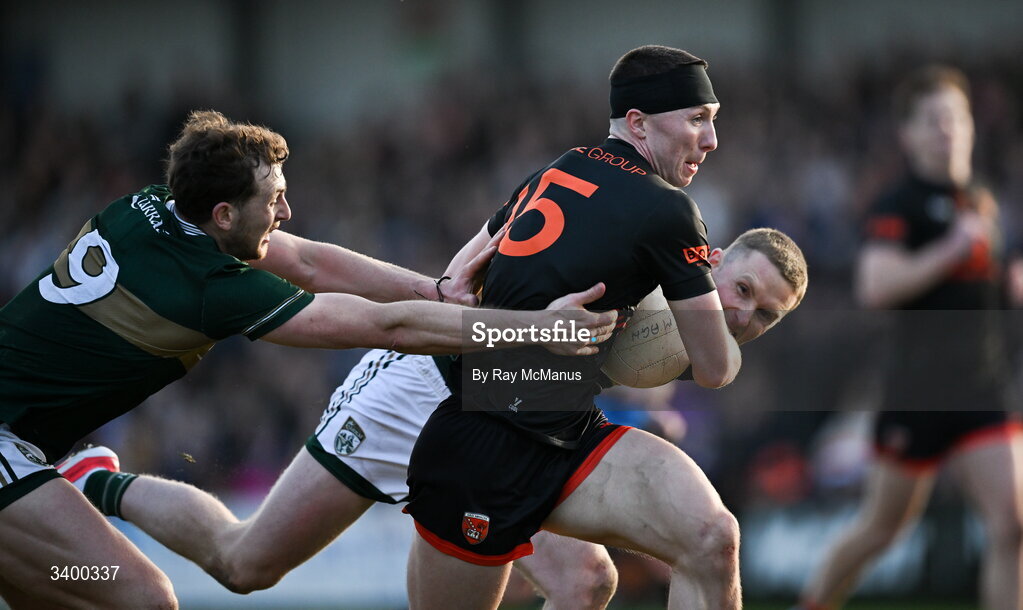 22 March 2026; Oisín Conaty of Armagh slips past Seán O'Brien, left, and Jason Foley of Kerry during the Allianz Football League Division 1 match between Armagh and Kerry at BOX-IT Athletic Grounds in Armagh. Photo by Ray McManus/Sportsfile
