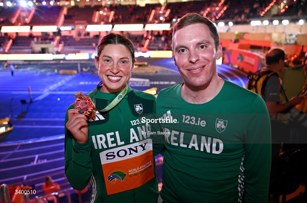 22 March 2026; Women's Pentathlon bronze medallist Kate O'Connor of Ireland, left, and Athletics Ireland Team Press Liason Rory Cassidy after day three of the World Athletics Indoor Championships at Kujawsko-Pomorska Arena in Torun, Poland. Photo by Sam Barnes/Sportsfile