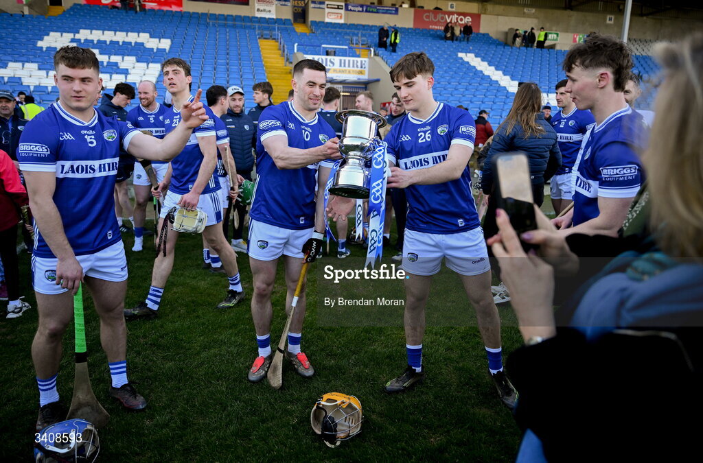 28 March 2026; James Keyes, second from left, and teammate Cormac Byrne of Laois pass the cup between them after the Allianz Hurling League Division 2 final match between Laois and Kerry at Laois Hire O'Moore Park in Portlaoise, Laois. Photo by Brendan Moran/Sportsfile