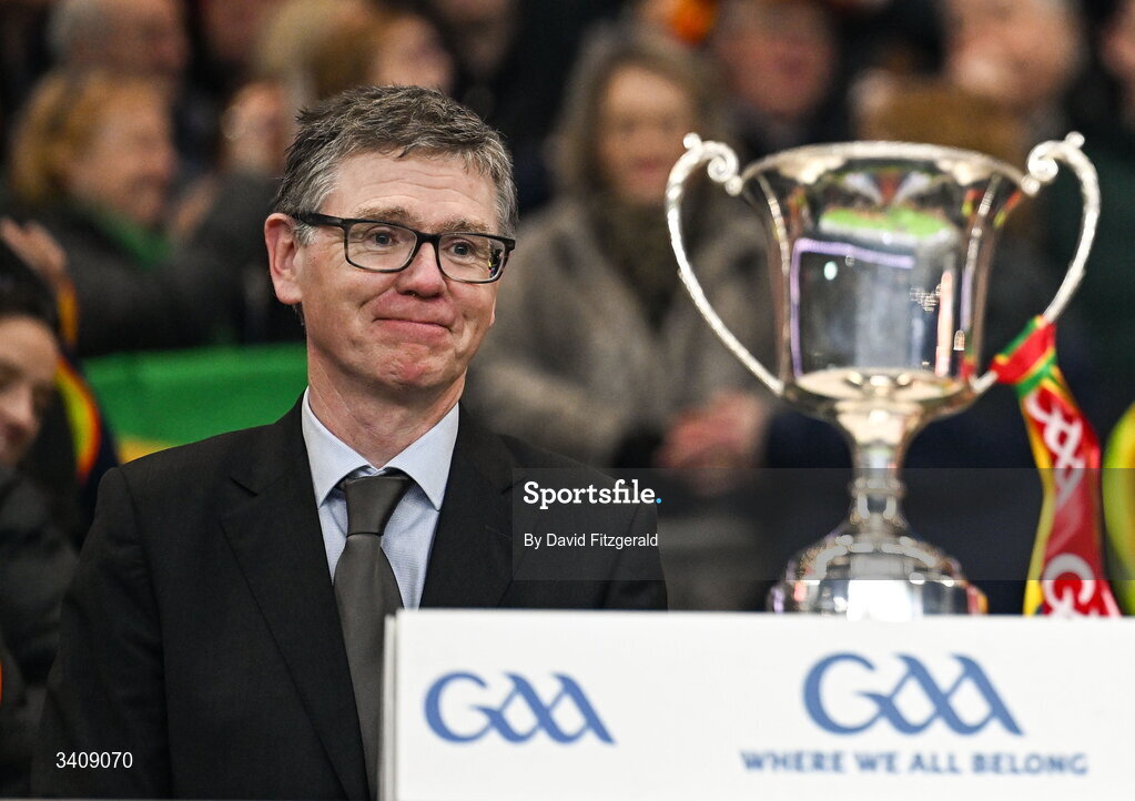 28 March 2026; Ard Stiúrthóir of the GAA Tom Ryan from Carlow looks at the cup with Carlow ribbons after the Allianz Football League Division 4 final match between Carlow and Longford at Croke Park in Dublin. Photo by David Fitzgerald/Sportsfile