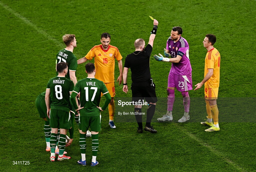 31 March 2026; North Macedonia goalkeeper Stole Dimitrievski is shown a yellow card by referee Iwan Arwel Griffith during the international friendly match between Republic of Ireland and North Macedonia at Aviva Stadium in Dublin. Photo by Ben McShane/Sportsfile