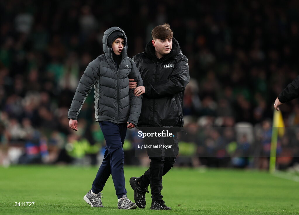 31 March 2026; A pitch invader is escorted off the field during the international friendly match between Republic of Ireland and North Macedonia at Aviva Stadium in Dublin. Photo by Michael P Ryan/Sportsfile