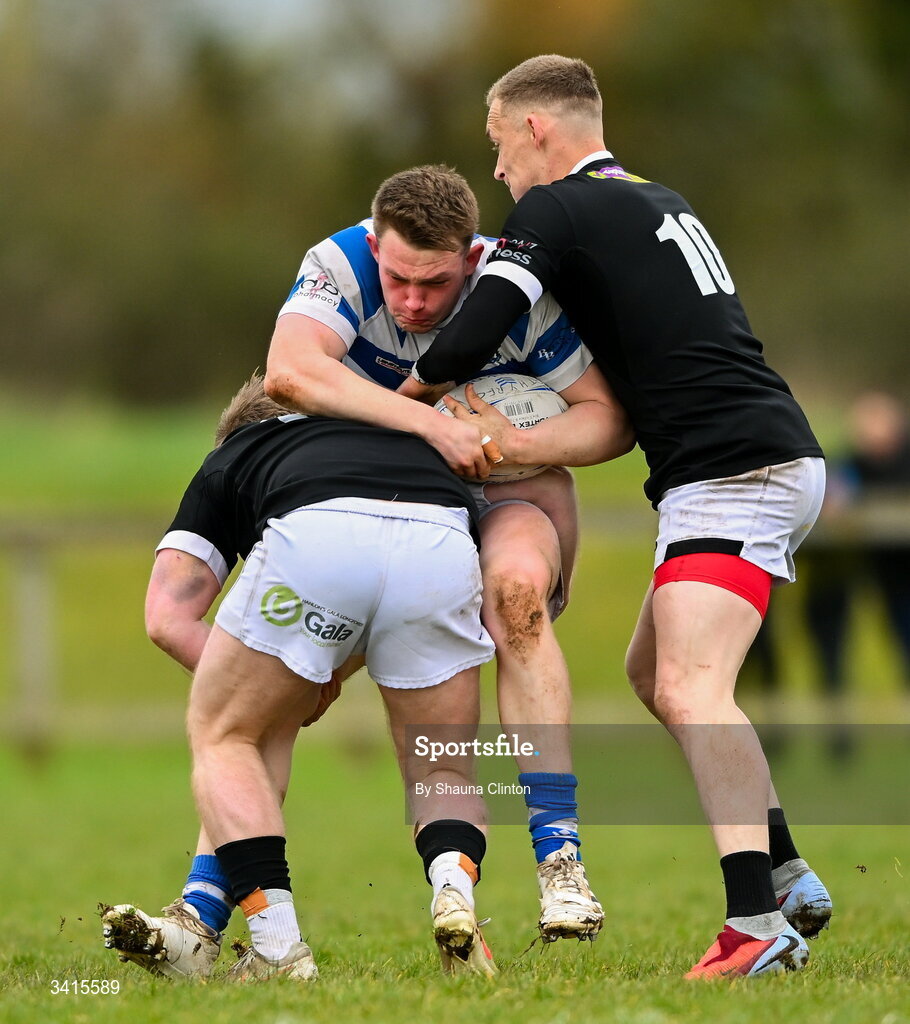 4 April 2026; Jack Henry of Athy RFC is tackled by Andrew Farrell, left, and Jayden Boshoff of Longford RFC during the Bank of Ireland Provincial Towns Cup semi-final match between Athy RFC and Longford RFC at Cill Dara RFC in Silken Thomas Park in Kildare. Photo by Shauna Clinton/Sportsfile