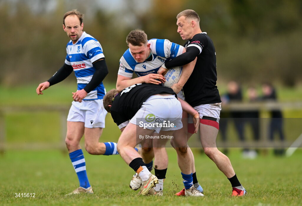 4 April 2026; Jack Henry of Athy RFC is tackled by Andrew Farrell, left, and Jayden Boshoff of Longford RFC during the Bank of Ireland Provincial Towns Cup semi-final match between Athy RFC and Longford RFC at Cill Dara RFC in Silken Thomas Park in Kildare. Photo by Shauna Clinton/Sportsfile