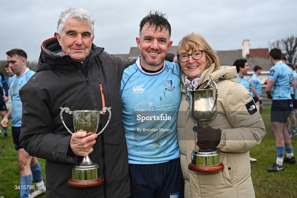 4 April 2026; MU Barnhall captain Rob Holt celebrates with his parents John and Pauline and the Energia AIL Division 2 trophy after the Energia Men's All-Ireland League Division match between MU Barnhall and Wanderers RFC at MU Barnhall RFC in Parsonstown, Kildare. Photo by Brendan Moran/Sportsfile