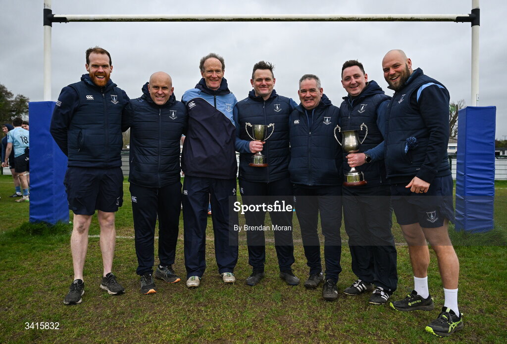 4 April 2026; MU Barnhall management, from left, Stephen Sheerin, Adrian Flavin, John Hayes, Tom McKeown, Sam Cawley, Darren Hudson and JP Botha celebrate with the Energia AIL Division 2 trophy after the Energia Men's All-Ireland League Division match between MU Barnhall and Wanderers RFC at MU Barnhall RFC in Parsonstown, Kildare. Photo by Brendan Moran/Sportsfile