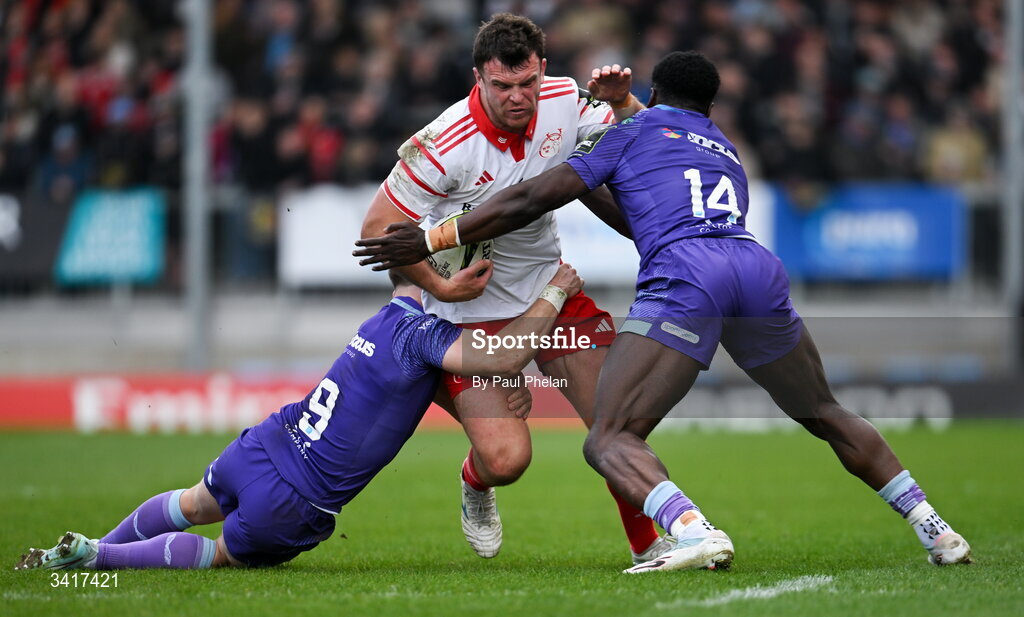 4 April 2026; Tom Farrell of Munster Rugby is tackled by Steve Varney and Paul Brown-Bampoe of Exeter Chiefs during the EPCR Challenge Cup match between Exeter Chiefs and Munster at Sandy Park in Exeter, England. Photo by Paul Phelan/Sportsfile