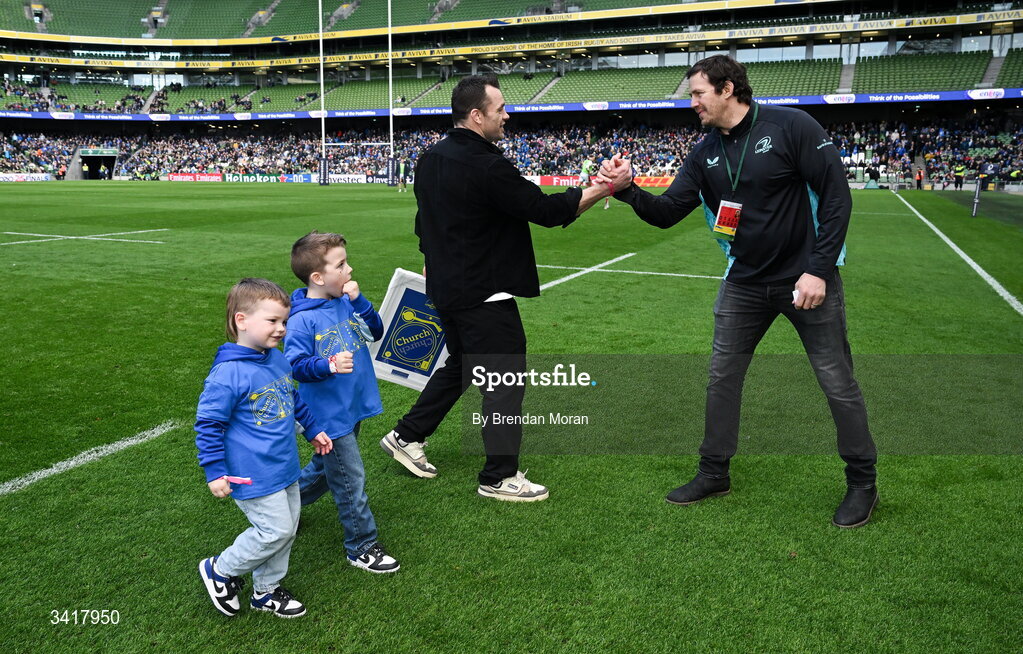 5 April 2026; Leinster record cap holder Cian Healy, accompanied by his sons Russell and Beau, with MC Mike McCarthy, after being interviewed during half-time in the Investec Champions Cup match between Leinster and Edinburgh at the Aviva Stadium in Dublin. Photo by Brendan Moran/Sportsfile