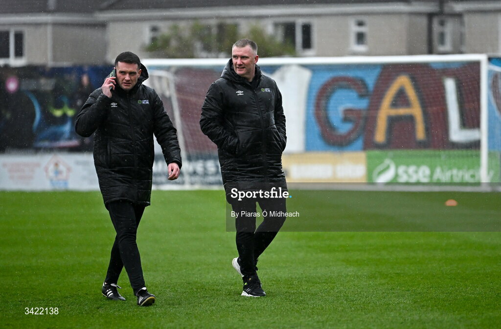 10 April 2026; Referee Rob Hennessy on the phone, alongside fourth official Mark Houlihan, after inspecting the wet pitch before the SSE Airtricity Men's Premier Division match between Galway United and Shelbourne at Eamonn Deacy Park in Galway. Photo by Piaras Ó Mídheach/Sportsfile