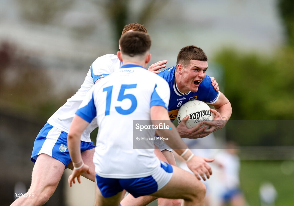 12 April 2026; Joe Higgins of Tipperary is tackled by Michael Curry, left, and Alan Dunwoody of Waterford during the Munster GAA Football Senior Championship quarter-final match between Waterford and Tipperary at Cappoquin Logistics Fraher Field in Waterford. Photo by Michael P Ryan/Sportsfile