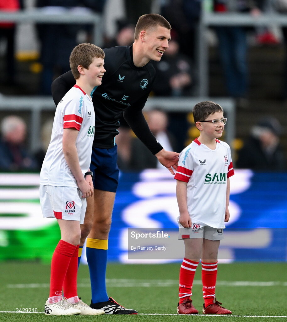 17 April 2026; Sam Prendergast of Leinster with Ulster mascots before the United Rugby Championship match between Ulster and Leinster at Affidea Stadium in Belfast. Photo by Ramsey Cardy/Sportsfile