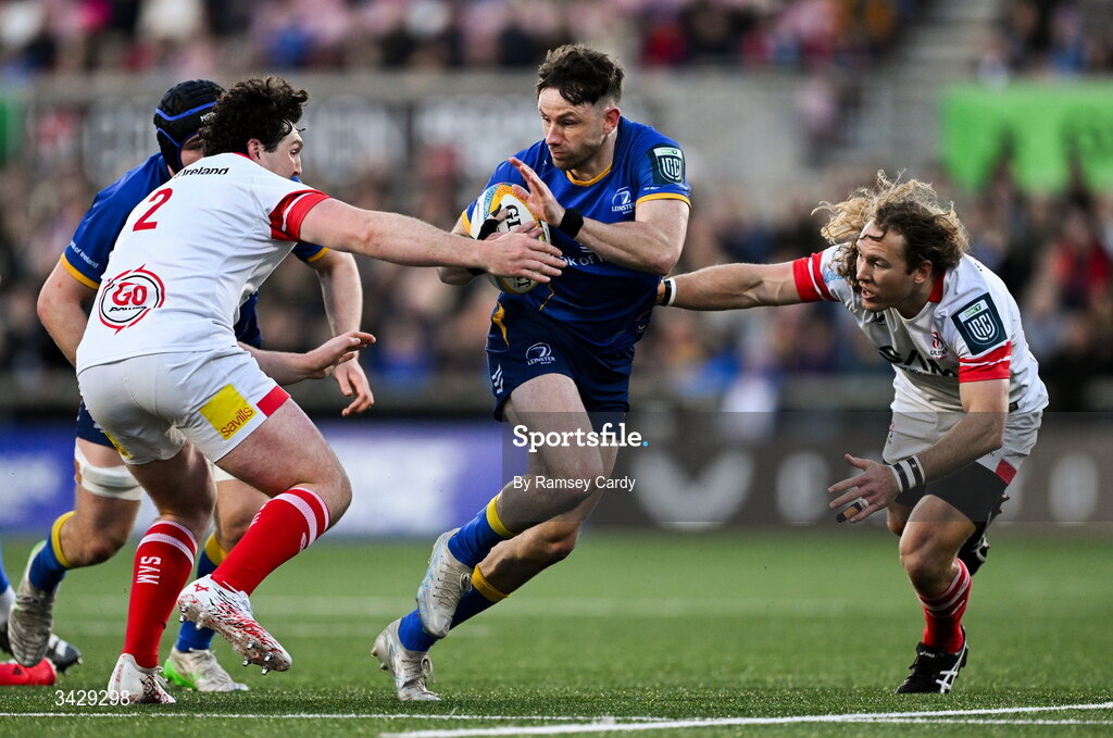 17 April 2026; Hugo Keenan of Leinster is tackled by Tom Stewart, left, and Werner Kok of Ulster during the United Rugby Championship match between Ulster and Leinster at Affidea Stadium in Belfast. Photo by Ramsey Cardy/Sportsfile