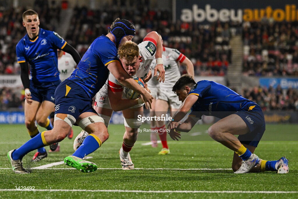 17 April 2026; Bryn Ward of Ulster on his way to scoring his side's first try despite the tackle of James Culhane, left, and Jimmy O'Brien of Leinster during the United Rugby Championship match between Ulster and Leinster at Affidea Stadium in Belfast. Photo by Ramsey Cardy/Sportsfile