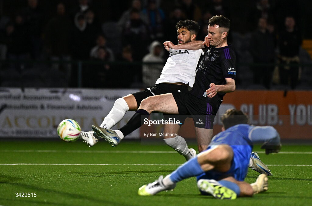 17 April 2026; Declan McDaid of Dundalk scores his side's first goal despite the tackle of Lee Devitt of Galway United during the SSE Airtricity Men's Premier Division match between Dundalk and Galway United at Oriel Park in Dundalk, Louth. Photo by Ben McShane/Sportsfile