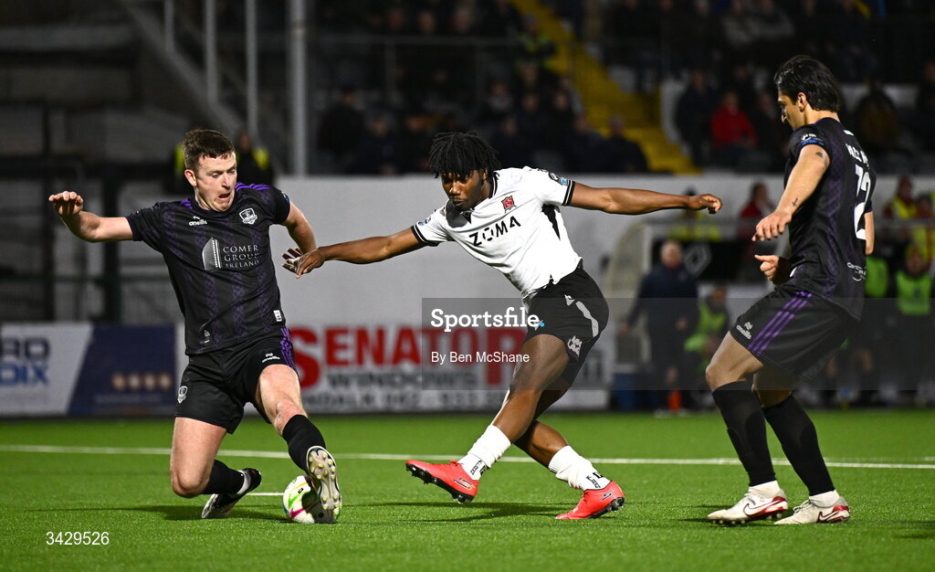 17 April 2026; Gbemi Arubi of Dundalk has a shot on goal despite the tackle of Killian Brouder of Galway United during the SSE Airtricity Men's Premier Division match between Dundalk and Galway United at Oriel Park in Dundalk, Louth. Photo by Ben McShane/Sportsfile