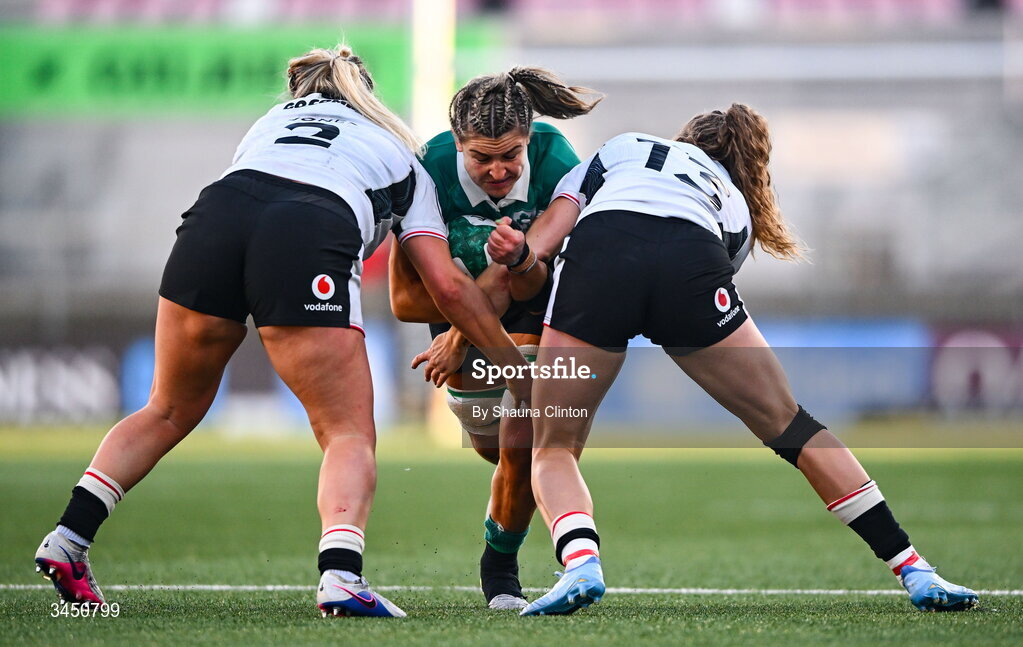 9 May 2026; Erin King of Ireland is tackled by Wales players Kelsey Jones, left, and Carys Cox during the Women's 6 Nations Rugby Championship match between Ireland and Wales at Affidea Stadium in Belfast. Photo by Shauna Clinton/Sportsfile