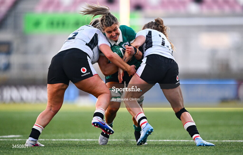 9 May 2026; Erin King of Ireland is tackled by Wales players Kelsey Jones, left, and Carys Cox during the Women's 6 Nations Rugby Championship match between Ireland and Wales at Affidea Stadium in Belfast. Photo by Shauna Clinton/Sportsfile