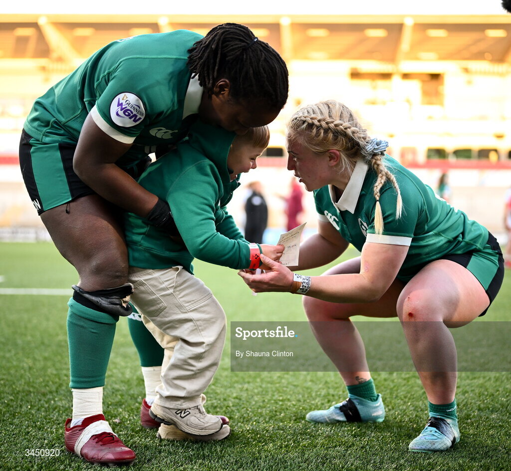 9 May 2026; Linda Djougang, left, and Neve Jones of Ireland with Bert, son of team-mate Ellena Perry, not pictured, after the Women's 6 Nations Rugby Championship match between Ireland and Wales at Affidea Stadium in Belfast. Photo by Shauna Clinton/Sportsfile