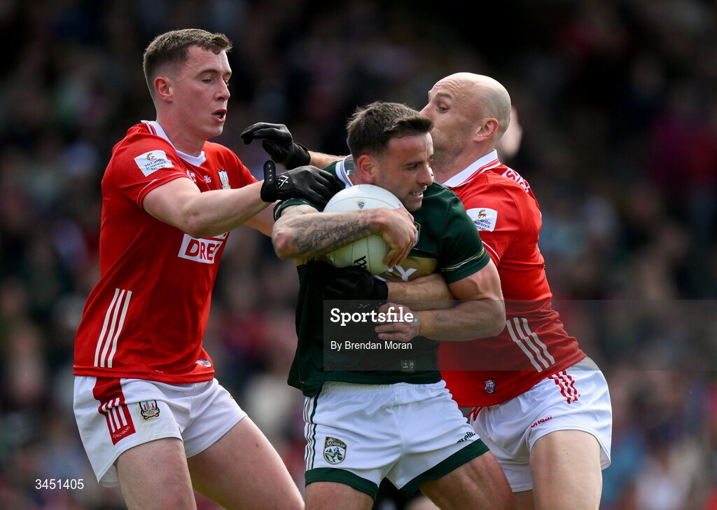 10 May 2026; Micheál Burns of Kerry is tackled by Luke Fahy, left, and Brian O’Driscoll of Cork during the Munster GAA Football Senior Championship final match between Kerry and Cork at Fitzgerald Stadium in Killarney, Kerry. Photo by Brendan Moran/Sportsfile