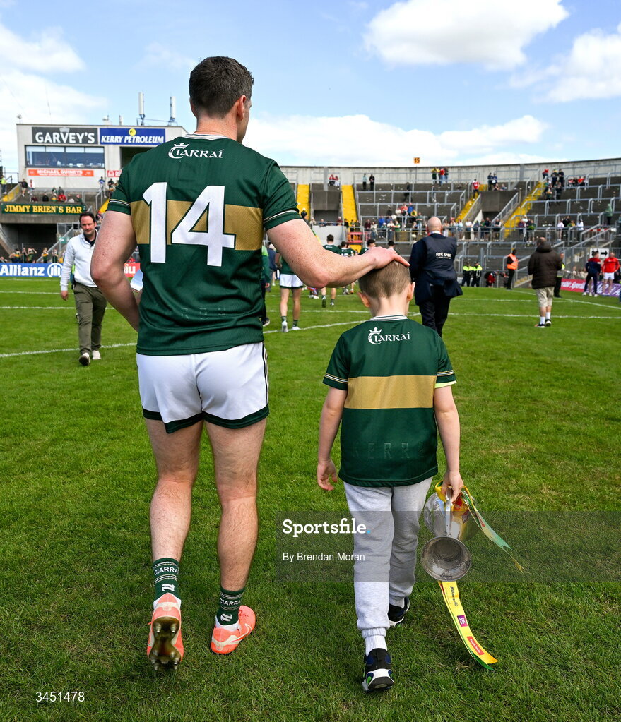 10 May 2026; Páidí Geaney, son of Kerry captain Paul Geaney, carries the Corn Pháidí Uí Shé, named in honour of his grandfather, legendary Kerry footballer Páidí Ó Sé, as they leave the pitch after the Munster GAA Football Senior Championship final match between Kerry and Cork at Fitzgerald Stadium in Killarney, Kerry. Photo by Brendan Moran/Sportsfile