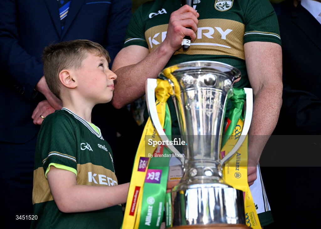 10 May 2026; Páidí Geaney, looks up at his father, Kerry captain Paul Geaney, as he makes his winning captain's speech, next to the Corn Pháidí Uí Shé, named in honour of legendary Kerry footballer Páidí Ó Sé, during the speeches after the Munster GAA Football Senior Championship final match between Kerry and Cork at Fitzgerald Stadium in Killarney, Kerry. Photo by Brendan Moran/Sportsfile