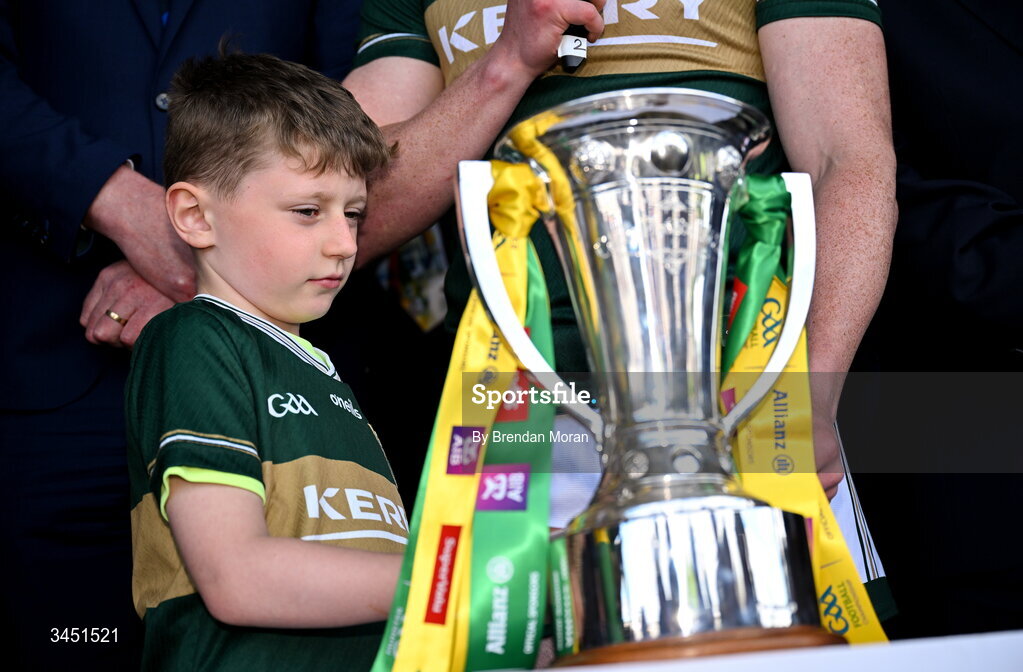 10 May 2026; Páidí Geaney, son of Kerry captain Paul Geaney, looks at the Corn Pháidí Uí Shé, named in honour of his grandfather, legendary Kerry footballer Páidí Ó Sé, during the speeches after the Munster GAA Football Senior Championship final match between Kerry and Cork at Fitzgerald Stadium in Killarney, Kerry. Photo by Brendan Moran/Sportsfile