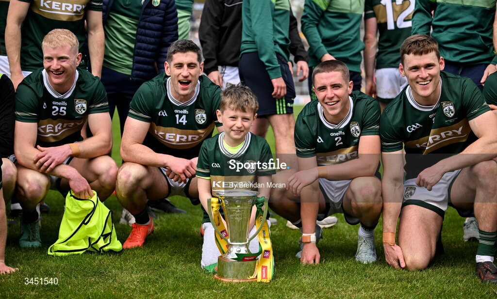 10 May 2026; Kerry captain Paul Geaney, his son Páidí, and teammates, from left, Joey Nagle, Evan Looney and Gavin White, celebrate with the Corn Pháidí Uí Shé, named in honour of legendary Kerry footballer Páidí Ó Sé, after the Munster GAA Football Senior Championship final match between Kerry and Cork at Fitzgerald Stadium in Killarney, Kerry. Photo by Brendan Moran/Sportsfile