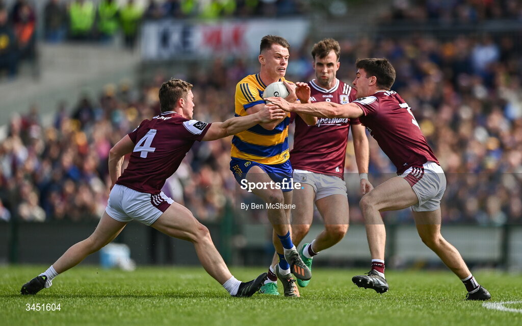 10 May 2026; Darragh Heneghan of Roscommon is tackled by Galway players, from left, Jack Glynn, Paul Conroy and Seán Kelly during the Connacht GAA Football Senior Championship final match between Roscommon and Galway at King & Moffatt Dr Hyde Park in Roscommon. Photo by Ben McShane/Sportsfile