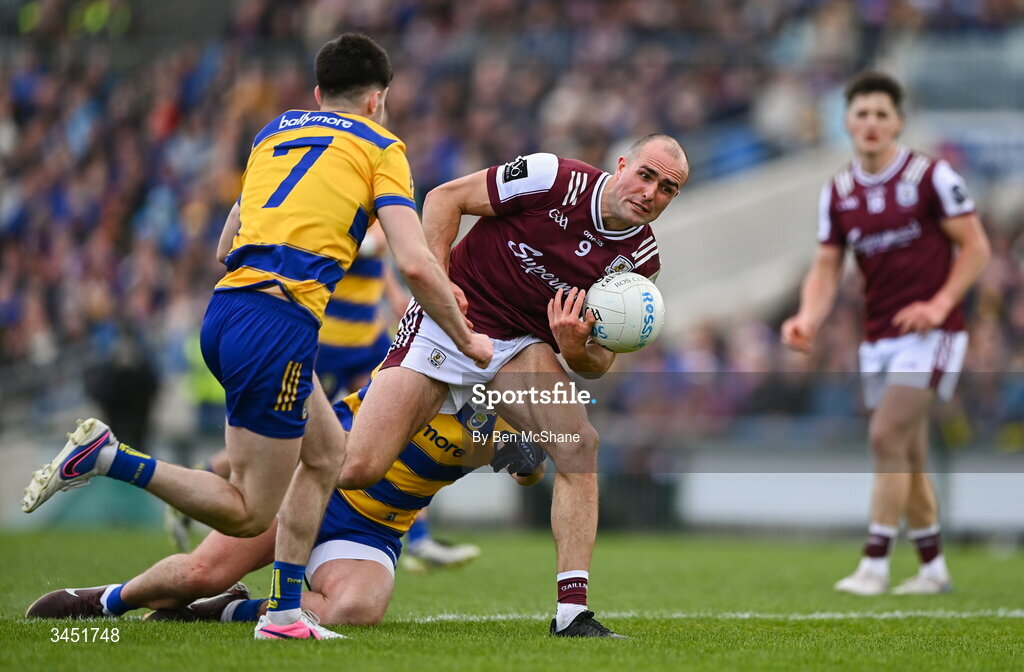 10 May 2026; John Maher of Galway is tackled by Enda Smith, hidden, and Senan Lambe of Roscommon during the Connacht GAA Football Senior Championship final match between Roscommon and Galway at King & Moffatt Dr Hyde Park in Roscommon. Photo by Ben McShane/Sportsfile