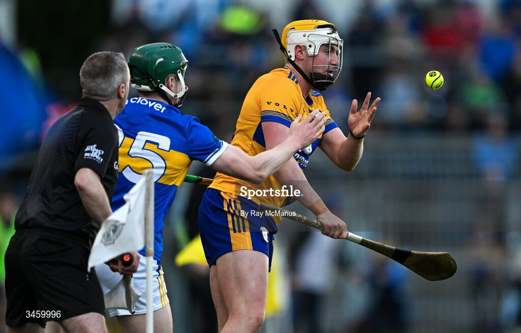16 May 2026; Sean Rynne of Clare is tackled by Darragh Stakelum of Tipperary under the watchful eyes of line umpire Shane Hynes during the Munster GAA Senior Hurling Championship Round 4 match between Tipperary and Clare at FBD Semple Stadium in Thurles, Tipperary. Photo by Ray McManus/Sportsfile
