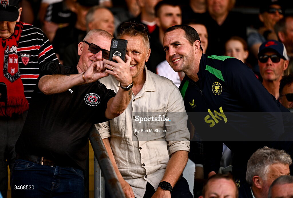25 May 2026; Republic of Ireland head coach Heimir Hallgrimsson, centre, and assistant coach John O'Shea take a selfie with Bohemians supporter Davy Keogh before the SSE Airtricity Men’s Premier Division match between Bohemians and Shamrock Rovers at Dalymount Park in Dublin. Photo by Ben McShane/Sportsfile