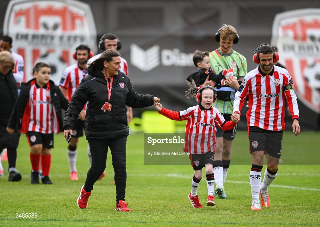 12 June 2026; Derry City captain Michael Duffy wears ear defenders as part of a Derry City awareness initiative while walking out with Karen Pyne and her daughter Eimile before the SSE Airtricity Men’s Premier Division match between Derry City and Bohemians at Find Insurance Celtic Park in Derry. Photo by Stephen McCarthy/Sportsfile