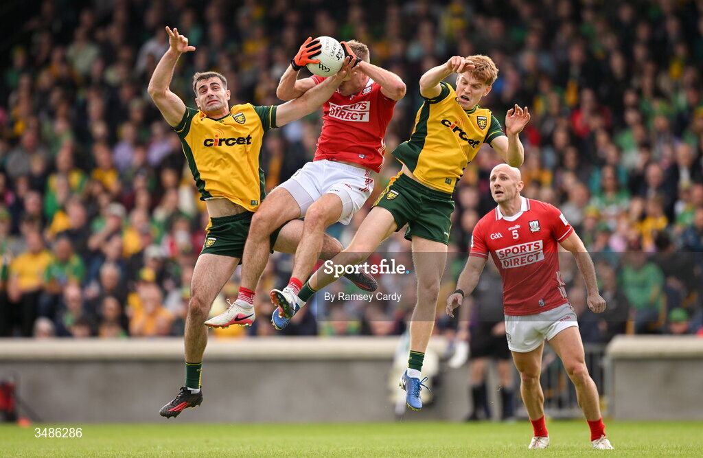 13 June 2026; Ian Maguire of Cork in action against Caolan McGonagle, left, and Ciaran Moore of Donegal during the GAA Football All-Ireland Senior Championship Round 2A match between Donegal and Cork at MacCumhaill Park in Ballybofey, Donegal. Photo by Ramsey Cardy/Sportsfile