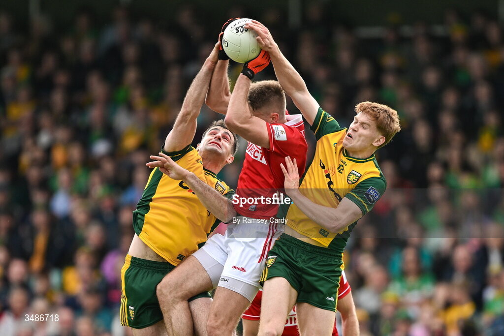 13 June 2026; Ian Maguire of Cork in action against Caolan McGonagle, left, and Ciaran Moore of Donegal during the GAA Football All-Ireland Senior Championship Round 2A match between Donegal and Cork at MacCumhaill Park in Ballybofey, Donegal. Photo by Ramsey Cardy/Sportsfile