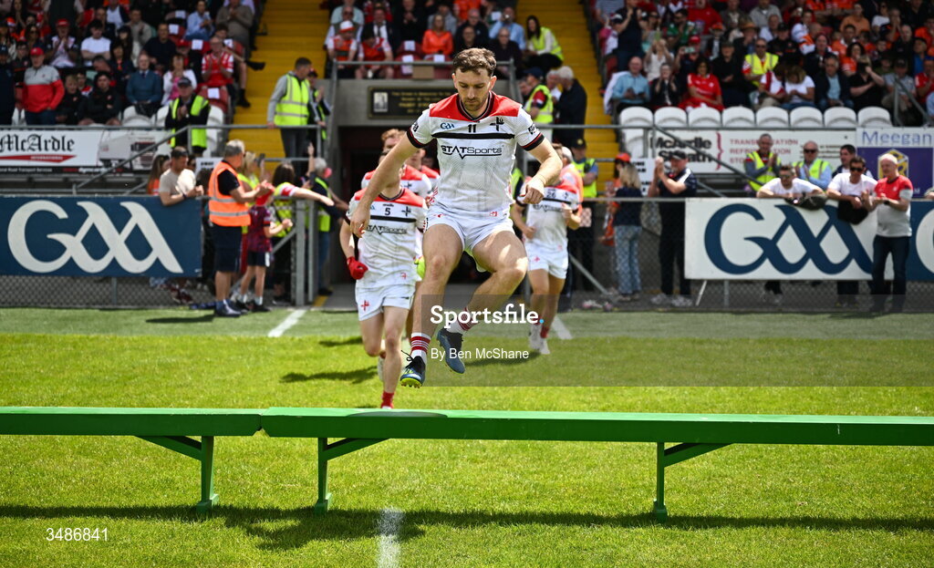 14 June 2026; Louth captain Sam Mulroy jumps over the bench in preperation for the team photograph before the GAA Football All-Ireland Senior Championship Round 2A match between Louth and Armagh at Páirc Grattan in Inniskeen, Monaghan. Photo by Ben McShane/Sportsfile