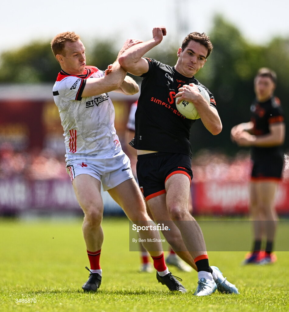 14 June 2026; Jarly Og Burns of Armagh is tackled by Donal McKenny of Louth during the GAA Football All-Ireland Senior Championship Round 2A match between Louth and Armagh at Páirc Grattan in Inniskeen, Monaghan. Photo by Ben McShane/Sportsfile