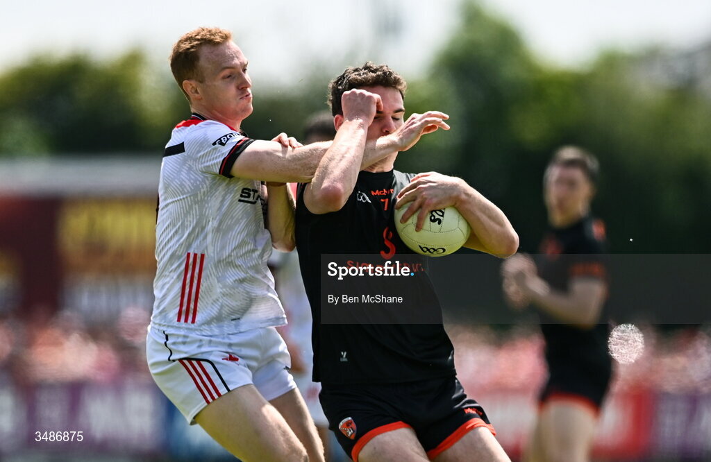 14 June 2026; Jarly Og Burns of Armagh is tackled by Donal McKenny of Louth during the GAA Football All-Ireland Senior Championship Round 2A match between Louth and Armagh at Páirc Grattan in Inniskeen, Monaghan. Photo by Ben McShane/Sportsfile