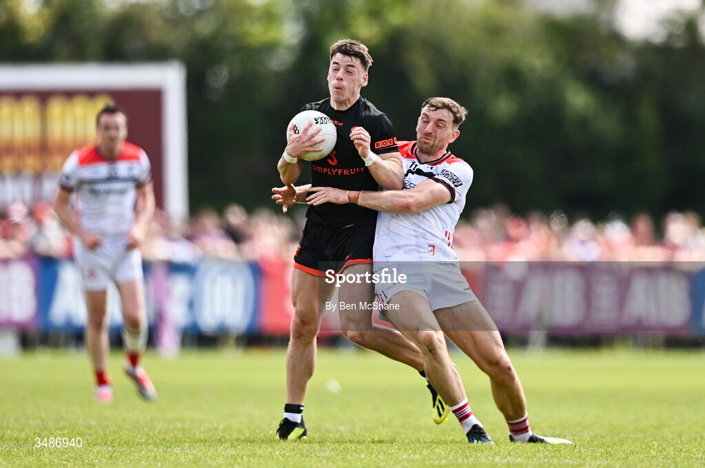14 June 2026; Tomas McCormack of Armagh is tackled by Sam Mulroy of Louth  during the GAA Football All-Ireland Senior Championship Round 2A match between Louth and Armagh at Páirc Grattan in Inniskeen, Monaghan. Photo by Ben McShane/Sportsfile