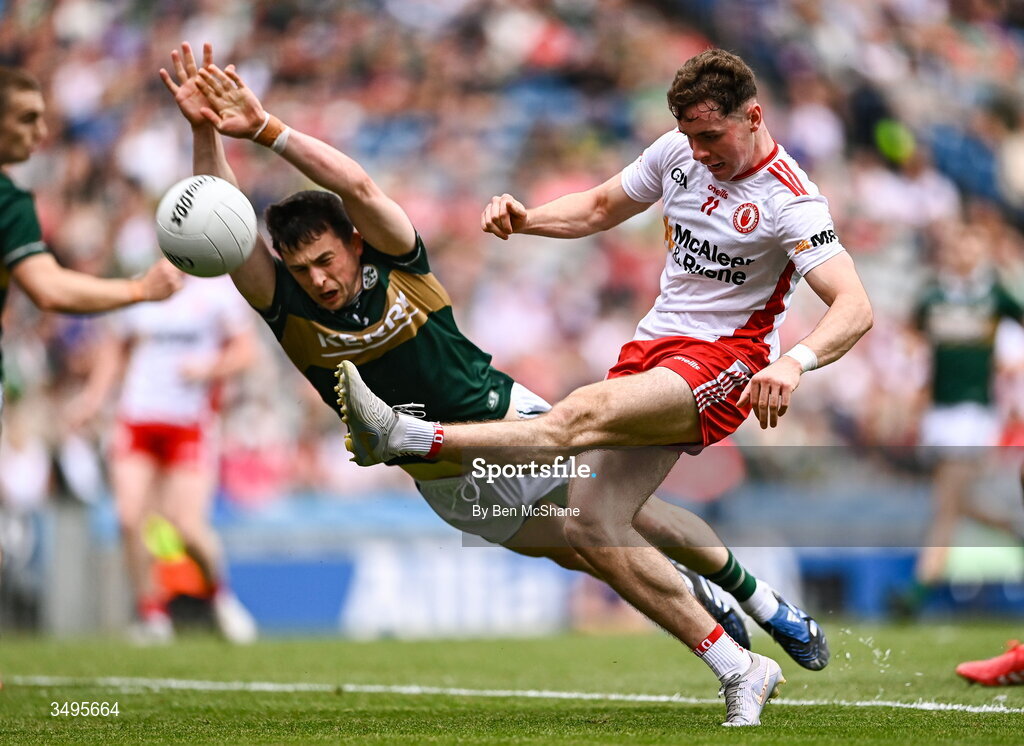 27 June 2026; Ronan Cassidy of Tyrone kicks a point despite the tackle of Paul Murphy of Kerry during the GAA Football All-Ireland Senior Championship quarter-final match between Kerry and Tyrone at Croke Park in Dublin. Photo by Ben McShane/Sportsfile