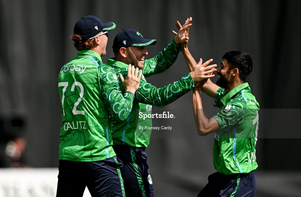 28 June 2026; Ross Adair, centre, celebrates with Ireland teammates Ben Calitz, left, and Jai Moondra after taking the wicket of Ishan Kishan of India during match two of the Spinny Cup Men's T20 International series between Ireland and India at Stormont in Belfast.  Photo by Ramsey Cardy/Sportsfile