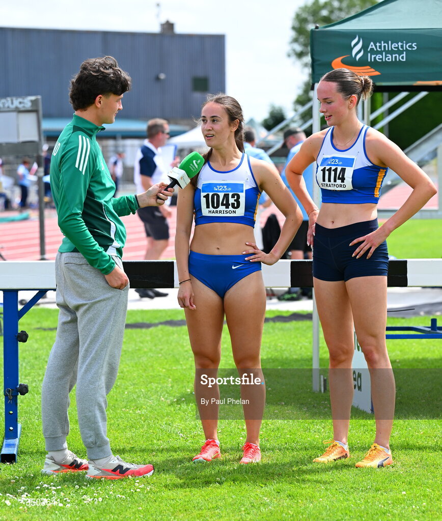 5 July 2026; Athletics Ireland content creator and marketing operations officer Cillian Sheerin interviews Lorena Harrison  and Aisling Stratford of Ratoath A.C., after they fininshed first sand second in the U23 women's 200m during day two of the 123.ie National U20 & U23 Track & Field Championships at Tullamore Harriers Athletics Club in Tullamore, Offaly. Photo by Paul Phelan/Sportsfile