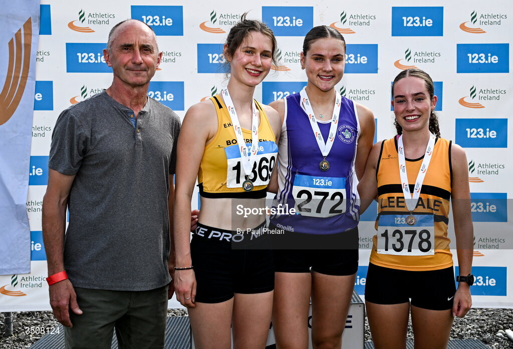 11 July 2026; Clara Casey of Foyle Valley A.C., third from left, in first, Emma Hunt of Bohermeen A.C., second from left, in second, Ella Dinan of Leevale A.C., right, in third, alongside Olympian Marcus O'Sullivan after the U19 girl's 1500m during day three of the 123.ie National Championships at Tullamore Harriers Athletics Club in Tullamore, Offaly. Photo by Paul Phelan/Sportsfile