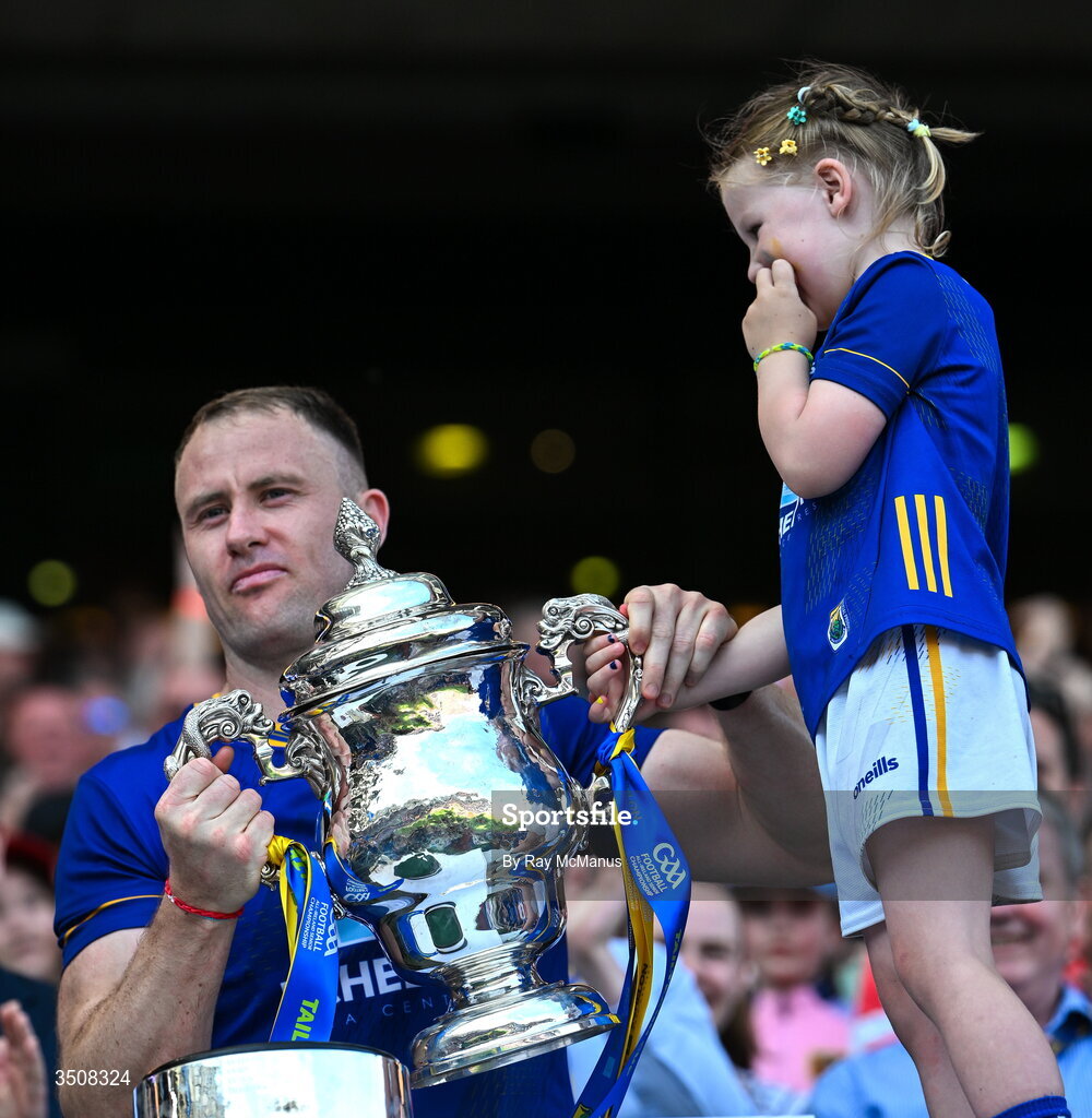 11 July 2026; Dean Healy of Wicklow and his five year old daughter, Fiádh, lift the Tailteann Cup after the final between Down and Wicklow at Croke Park in Dublin. Photo by Ray McManus/Sportsfile