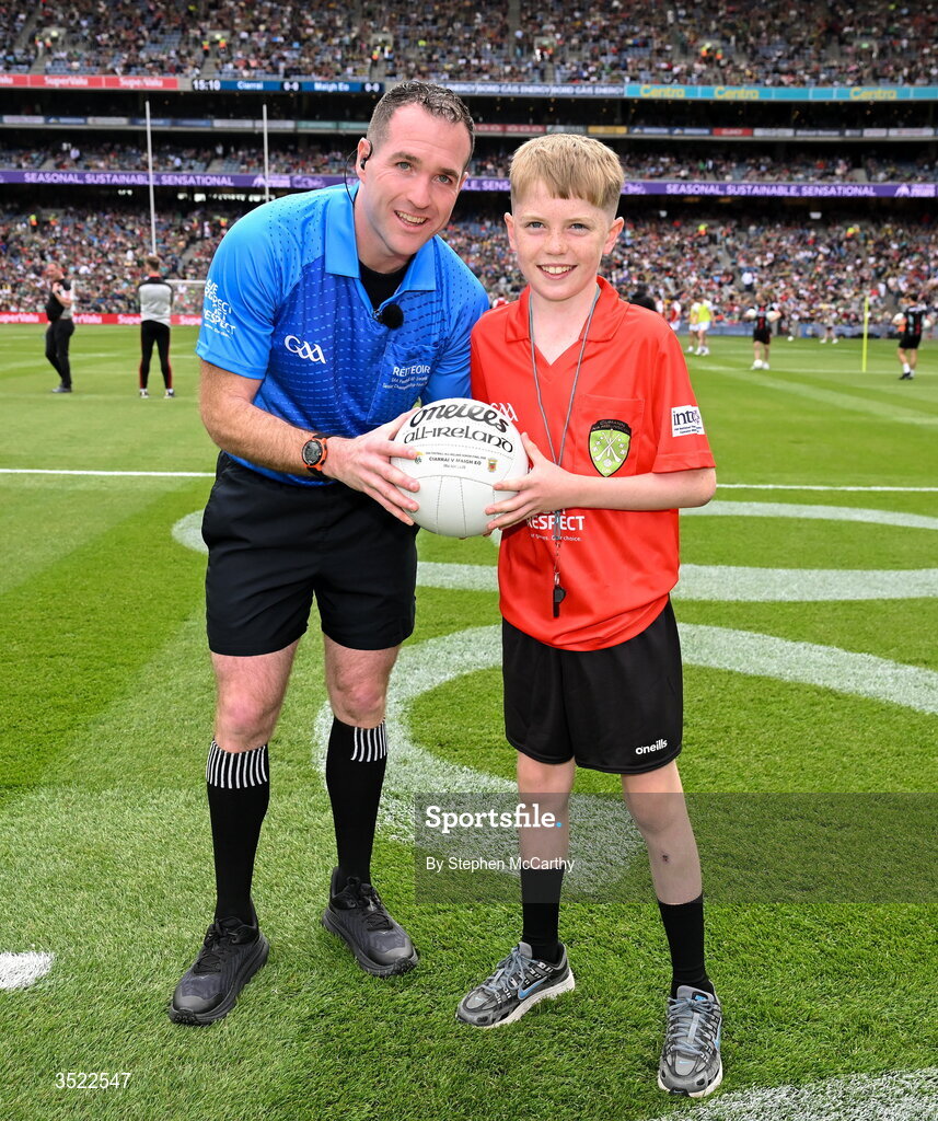26 July 2026; Darragh Ó Raifeartaigh, aged 12, from Swords in Dublin, right, presents the match ball to referee Martin McNally ahead of the GAA Football All-Ireland Senior Championship final match between Kerry and Mayo at Croke Park in Dublin. Photo by Stephen McCarthy/Sportsfile
